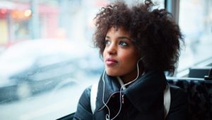 young girl listening to music on public transport